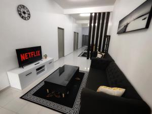 淡马鲁Homestay Temerloh Near Hospital Wi-Fi Netflix的客厅配有黑色沙发和电视