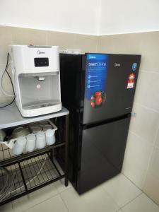 淡马鲁Homestay Temerloh Near Hospital Wi-Fi Netflix的黑色冰箱,上面有咖啡机
