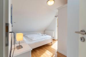 KarninFerienhaus Karnin B的一间卧室配有一张床和一张带台灯的桌子
