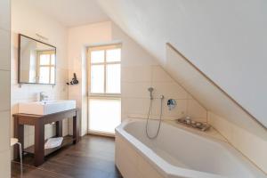 KarninFerienhaus Karnin B的浴室配有盥洗盆、浴缸和盥洗盆