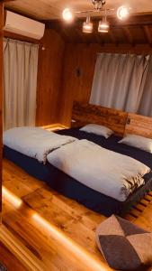 奄美Yamato inn - Vacation STAY 86368v的铺有木地板的客房内的两张床