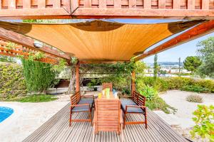 珊瑚湾Villa Demiana by Ezoria Villas的凉亭下带桌椅的天井