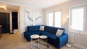 乌斯特卡Apartamenty Sun & Snow Stare Miasto Ustka的客厅配有蓝色的沙发和桌子