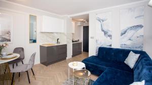 乌斯特卡Apartamenty Sun & Snow Stare Miasto Ustka的一间带蓝色沙发的客厅和一间厨房