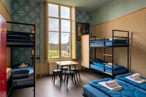 东卡佩勒Stayokay Hostel Domburg的客房设有双层床、桌子和书桌。