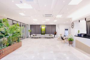 全州市Hotel Arari的配有白色家具和盆栽植物的办公大厅