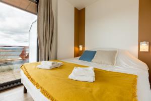 朗戈涅Les Lofts du Grand Lac de Lozère的一间卧室配有一张大床和毛巾