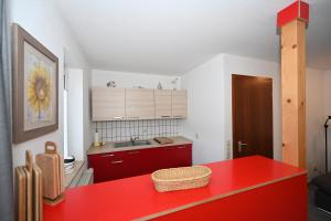 乌埃克尔明德Lagunenstadt Ueckermünde AG的厨房配有红色的柜台和红色的桌子