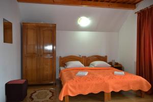 瓦杜伊泽Pensiunea Teodora Teleptean的一间卧室配有一张带橙色毯子的床