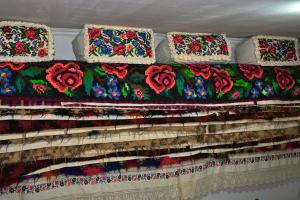 瓦杜伊泽Pensiunea Teodora Teleptean的墙上有一堆毯子,上面有鲜花
