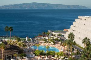 圣地亚哥港Landmar Playa La Arena的享有带游泳池和海洋的度假村的空中景致