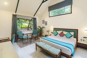 乌代浦Aranya Vilas的一间卧室配有床、椅子和窗户