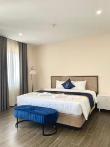 富国Kim Boutique Hotel的一间卧室配有一张大床和蓝色凳子
