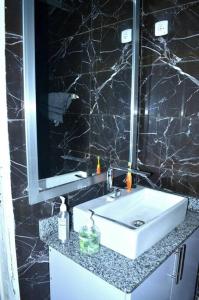 布琼布拉Bujumbura Sweet Home - Maison bien équipée avec voiture gratuite的浴室设有白色水槽和镜子