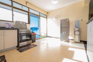 内罗毕Art-inspired 3BR Apartment的厨房配有炉灶和冰箱。