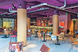 乌得勒支Stayokay Hostel Utrecht Centrum的餐厅设有桌椅和紫色天花板。