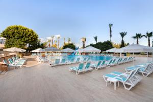 马赫姆拉Euphoria Comfort Beach Alanya的一个带蓝色和白色椅子及遮阳伞的游泳池