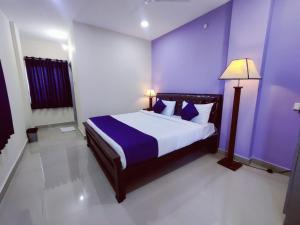 商沙巴Hotel Prime Classic的一间卧室设有一张紫色墙壁的大床