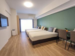 大阪ESLEAD HOTEL Osaka Ebisu的酒店客房设有两张床和绿色的墙壁。