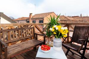 威尼斯Ca' Degli Antichi Giardini Apartments的阳台上摆放着鲜花和一碗水果的桌子