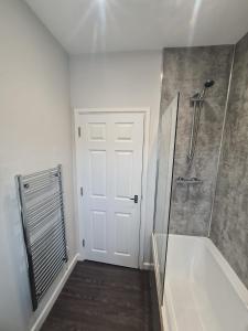 巴恩斯利APARTMENT in BARNSLEY CENTRAL的带淋浴的浴室和白色门