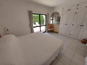 阿尔曼萨Ancão Beach Apartment的白色的卧室设有白色的床和窗户。