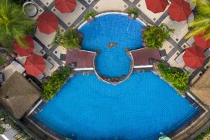 雅加达Hotel Ciputra Jakarta managed by Swiss-Belhotel International的享有带红伞的游泳池的顶部景致