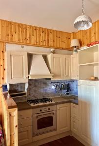 坎波迪焦韦MAGAVE's House的厨房配有白色橱柜和炉灶烤箱。