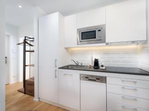 维也纳MyFavorit by Duschel Apartments Vienna的白色的厨房配有水槽和微波炉