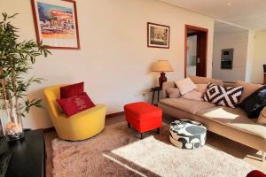 阿尔坎塔里利亚Modern 3Bedroom Duplex W/Pool by LovelyStay的带沙发和红色凳子的客厅