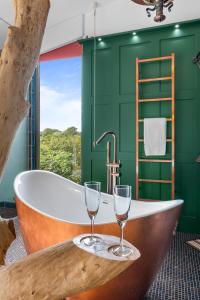 南安普敦Ivy Cottage Holiday Cabins的带浴缸和2个酒杯的浴室