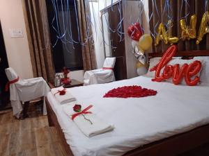 KoynanagarVinee's Kitchen and Motel的一张红玫瑰床,上面有爱的宣言