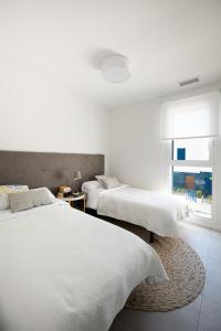 弗拉门卡海滩Turquesa del Mar - Max Beach Golf - Large Sunny Terrace Apartment的白色客房的两张床,设有窗户