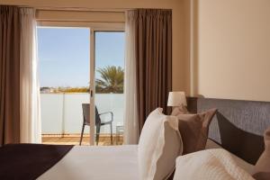 马略卡岛帕尔马Sercotel Hotel Zurbarán Palma的一间卧室设有一张床,享有阳台的景色