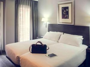 马德里马德里中央美居酒店的一间酒店客房,配有一张带袋子的床