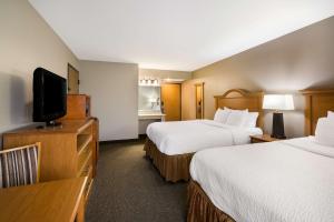 迈诺特Revel Hotel Minot - SureStay Collection by Best Western的酒店客房设有两张床和一台平面电视。
