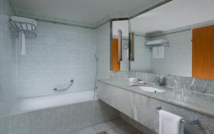 布加勒斯特布加勒斯特JW万豪大酒店的一间带水槽、浴缸和镜子的浴室