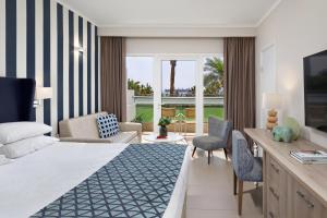 埃拉特Neptune Eilat By Dan Hotels的酒店客房设有床和客厅。