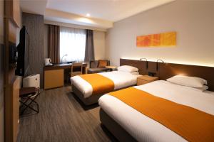 札幌北海道札幌大通柔婕阁酒店的酒店客房配有两张床和一张书桌