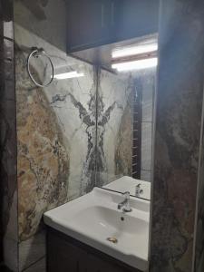 瓦尔卡拉AARONIC STAY的浴室配有白色水槽和大理石墙