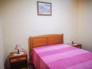 Santana de CambasCasa do Rosa - Santana de Cambas的一间卧室配有一张粉红色的床,桌子上配有两盏灯