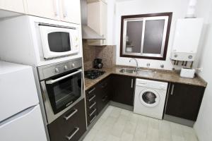 萨洛BAHIA II HomeStay by Turismar的厨房配有微波炉、洗衣机和烘干机
