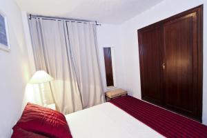 萨洛BAHIA II HomeStay by Turismar的一间卧室配有床、木制橱柜和窗户。