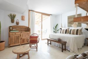 米乔尔海滩Can Tres Formentera的卧室配有1张床、1张桌子和1把椅子