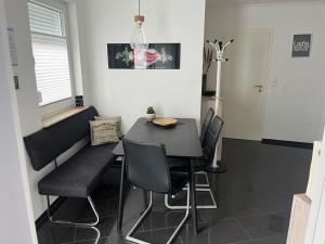 布尔沙伊德Pension Apartment Burscheid的一间用餐室,配有黑色的桌子和椅子