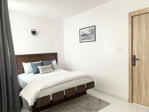 拉各斯Sigma Base Apartments的卧室配有白色墙壁的床