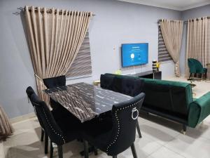 DawhwenyaSpacious Luxury 3Bed Hse in Tema - Netflix Wi-fi的一间带桌椅和沙发的用餐室