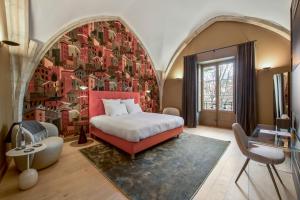里昂Les Suites de l'Ile Barbe的一间卧室配有一张床和壁画墙