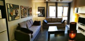 罗萨里奥港海滩附近2V豪华公寓 的客厅配有两张沙发和一张桌子