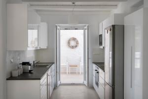 圣玛丽亚White Santa Maria Villa的厨房配有白色橱柜,门通往用餐室